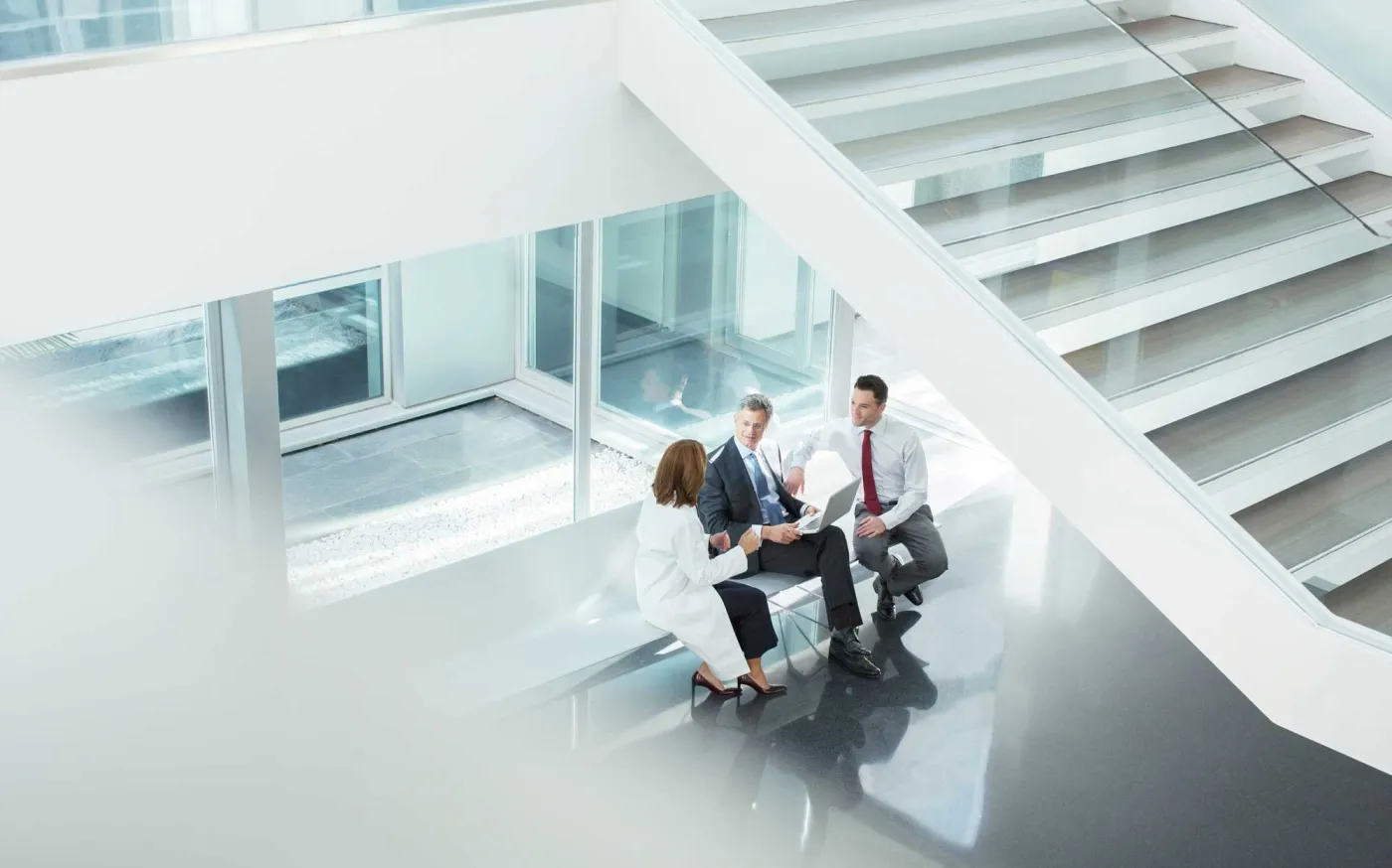 doctor and administrators talking in hospital lobby